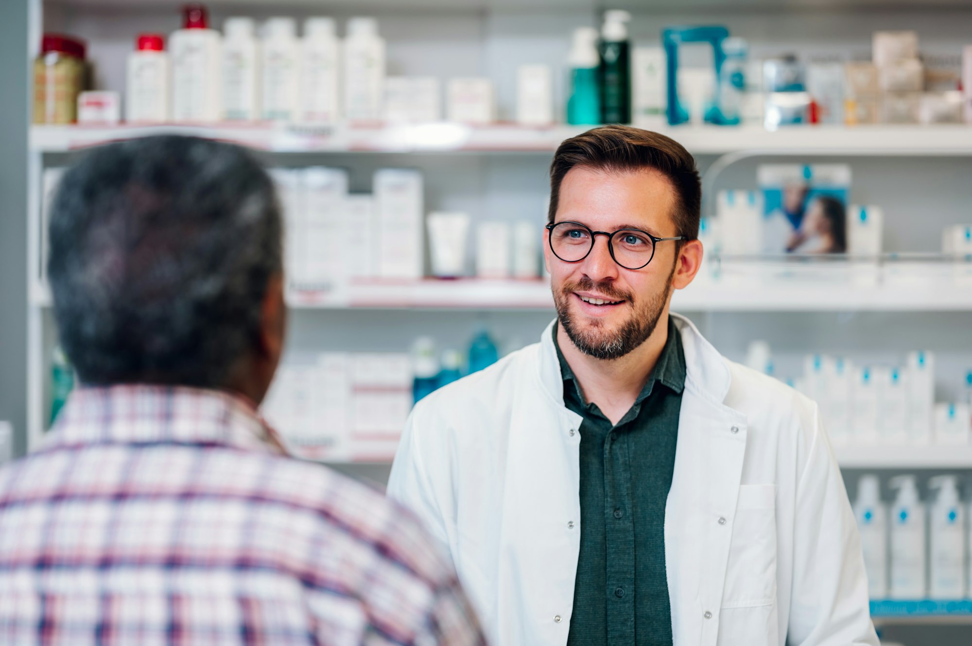 Portrait of a male pharmacist working at the counter in pharmacy